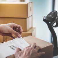 Home delivery service and working service mind, Woman working install serial barcode to confirm before sending customer in post office.
